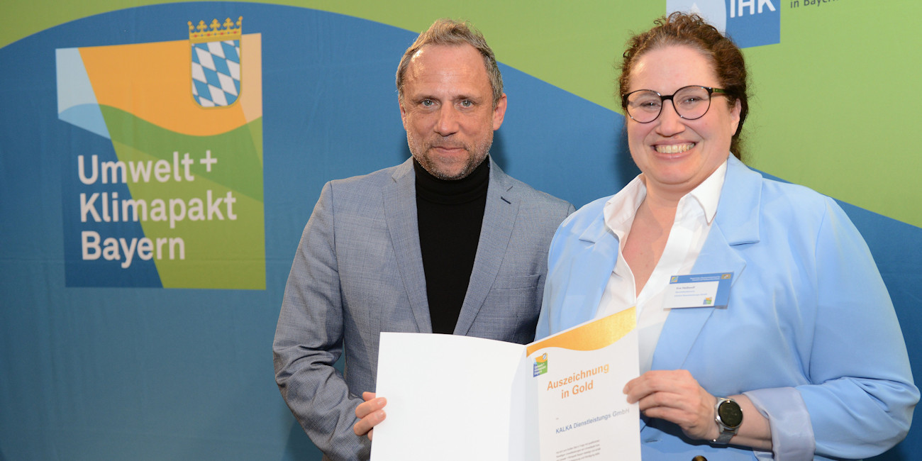 Staatsminister Thorsten Glauber und Eva Heißwolf vor einemBanner des Staatsministerium für Umwelt und Verbraucherschutz Umwelt + Klimapakt Bayern