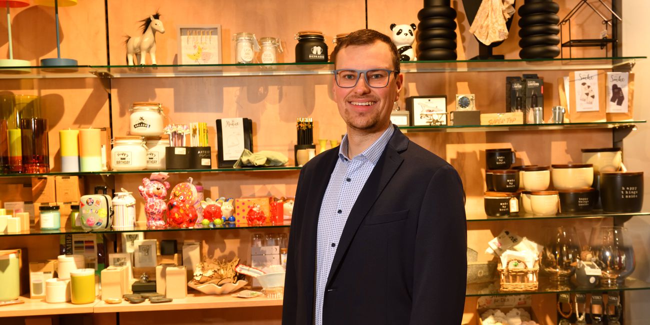 Philipp Hutter steht vor einer großen Auswahl des Sortiments in seinem Ladengeschäft.
