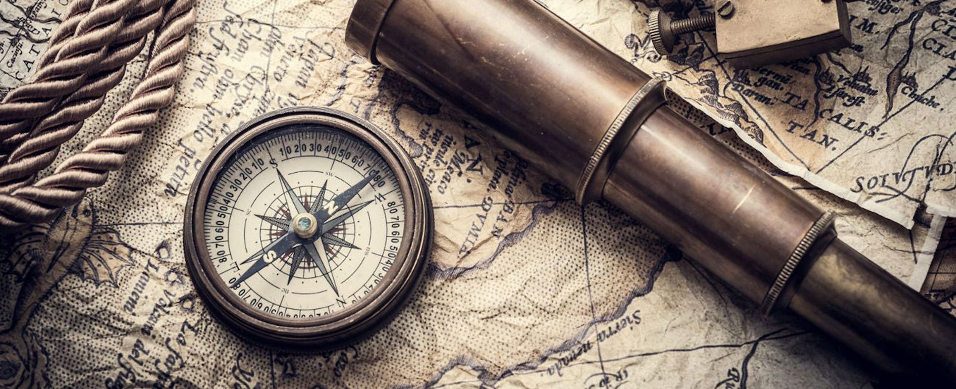 Ein Kompass und ein Fernrohr liegen auf einer Landkarte